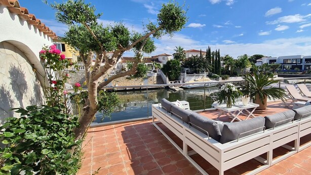 Una terraza en la azotea con mobiliario exterior, piscina y vistas de los edificios circundantes.