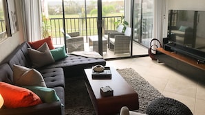 Una sala de estar con sofá, mesa de centro y televisor.