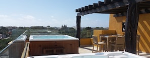Terraço no telhado com hidromassagem, móveis de exterior e vista desobstruída da paisagem urbana.