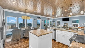 A spacious kitchen with wooden ceiling, white cabinetry, and a large island. - Amazing View, Gorgeous Beachfront, Huge Deck, Luxury Retreat-Sleeps 14, Starlink (Crystal Beach)