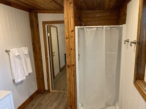 Tina con regadera, toallas, papel de baño 