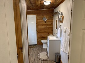 Tina con regadera, toallas, papel de baño 