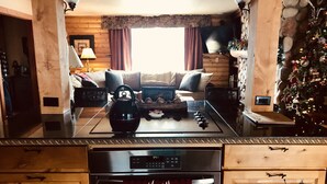 Un salon chaleureux avec une cheminée, une table basse et un sapin de Noël.