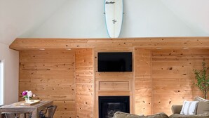 A modern kitchen with a wooden wall, a ceiling fan, a surfboard, and a fireplace. - Lake House Is Close To Minneapolis, But Far From Your Normal Routine.   (Zimmerman)