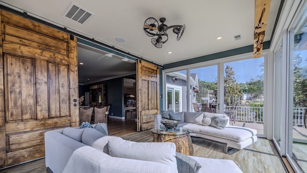 A spacious living area with a large white sofa, a wooden coffee table, and a ceiling fan. - Upscale Lakefront Luxury at Lake of the Ozarks - Private Dock, Quiet Cove (Lake Ozark)