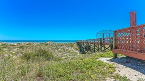 A wooden boardwalk leading to a beach with a clear blue sky. - Direct Ocean Front Condo With Heated Pool Located Directly on the Ocean (St Augustine)