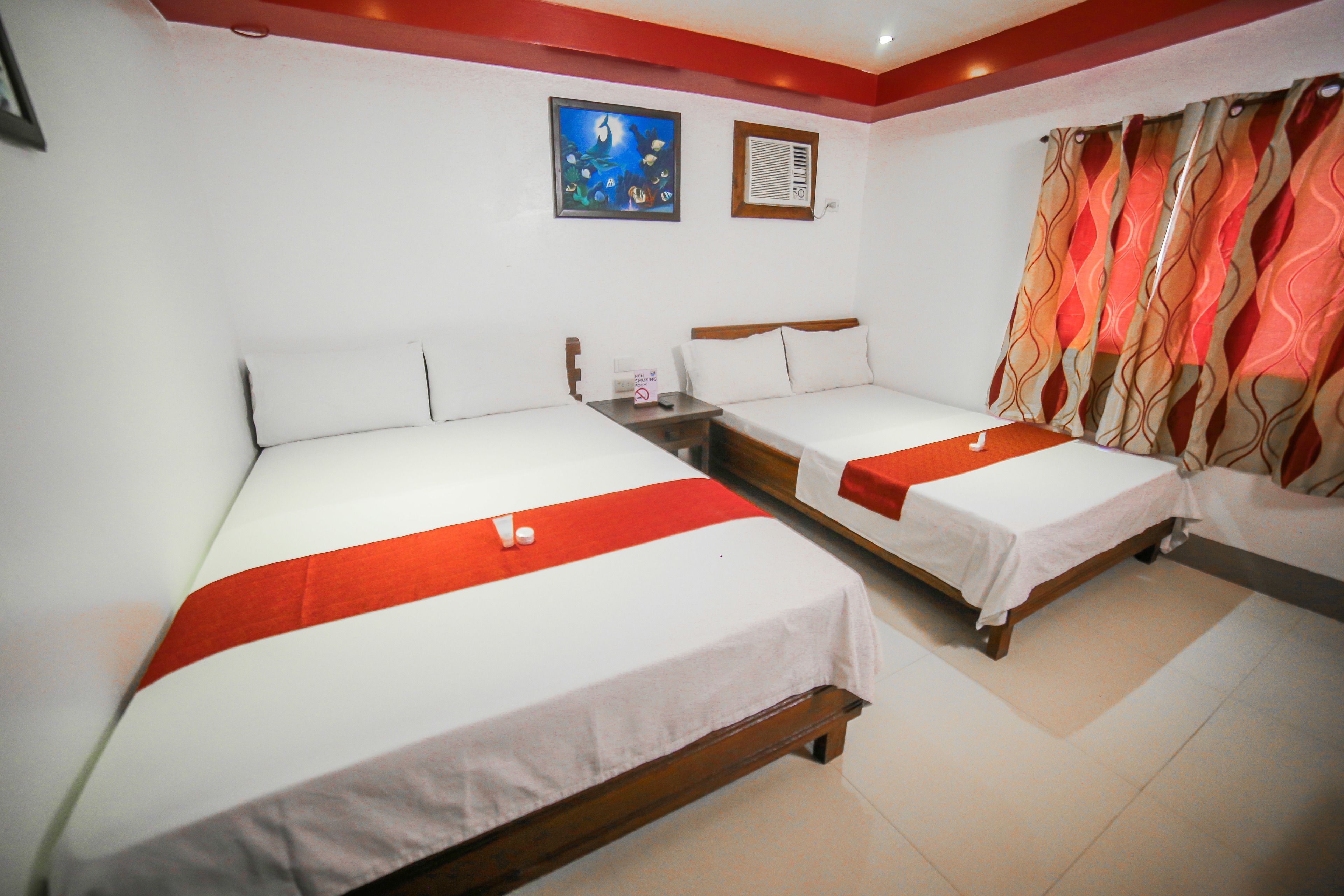 Una habitación de hotel con dos camas individuales, una mesita de noche, un cuadro y una ventana con cortinas.