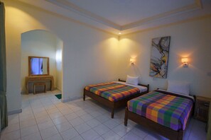 A hotel room with two wooden beds, a small desk, and a mirror. - Pramewari Homestay (Ubud)