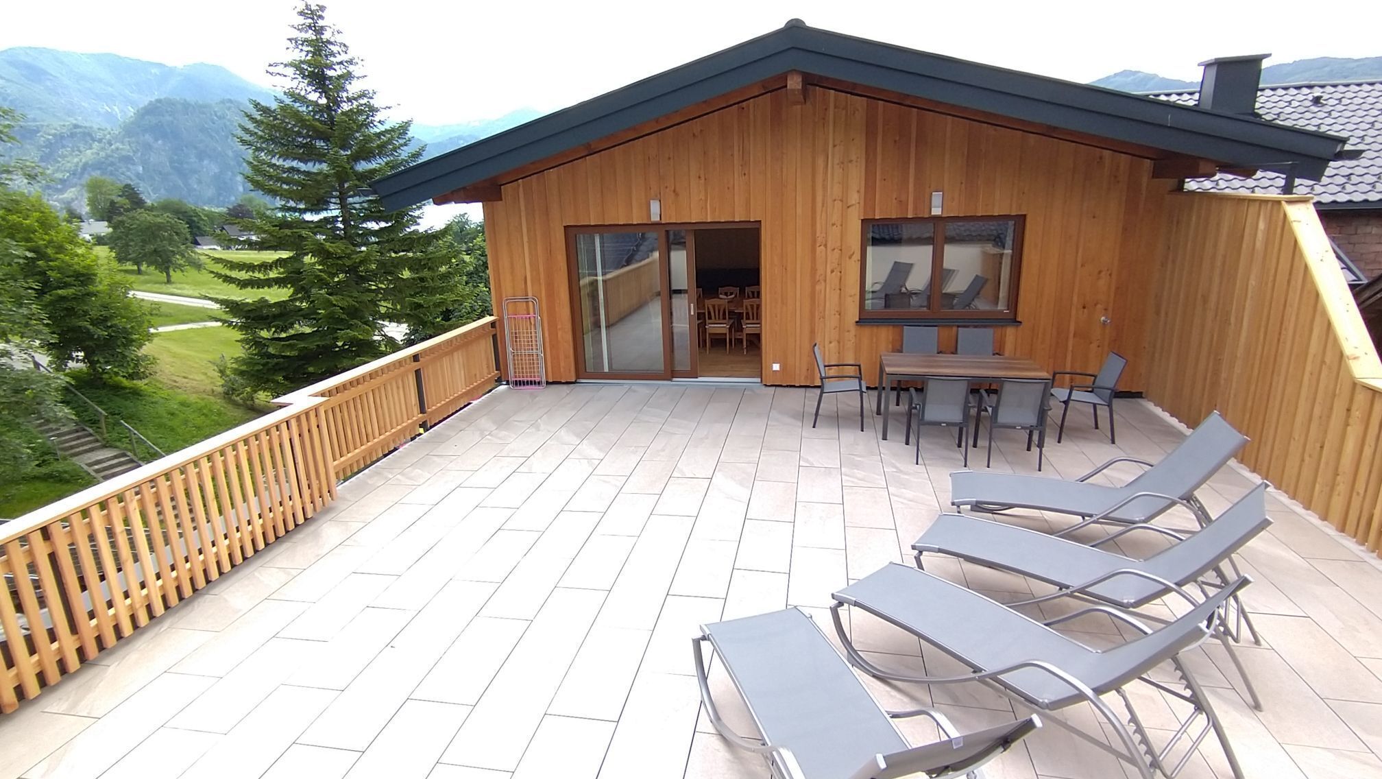 Une cabane en bois dotée d’un balcon, d’un espace salon extérieur et offrant une vue sur les montagnes.