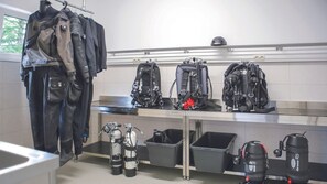 Un vestuario limpio y ordenado con múltiples taquillas, un tendedero y diverso equipo de buceo.