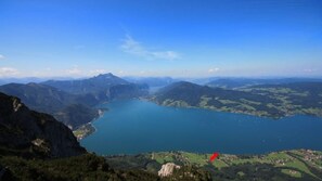 Un paisaje montañoso con un lago y un pequeño pueblo.