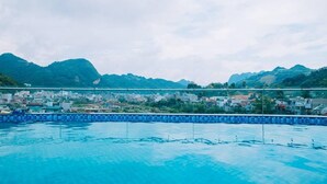 Ein Pool mit Blick auf eine Stadt und Berge im Hintergrund.