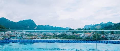 Una piscina techada, sombrillas, sillones reclinables de piscina