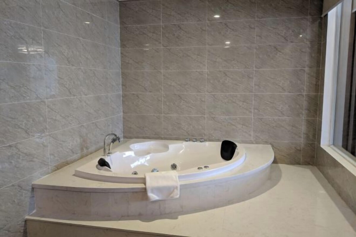 A modern bathroom with a freestanding bathtub, a vanity, and a window.