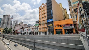 Un hôtel à plusieurs étages, reconnaissable à son grand panneau « Star Town Inn », situé juste à côté d’une rue très fréquentée, bordée de véhicules et dotée d’un trottoir pour les piétons.