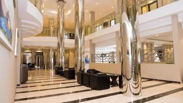 Un hall amplio con techo alto, suelos de mármol pulido y mobiliario moderno.