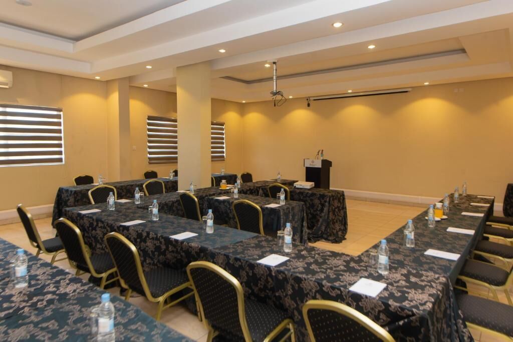 Un salón de conferencias con varias mesas, sillas y un atril.