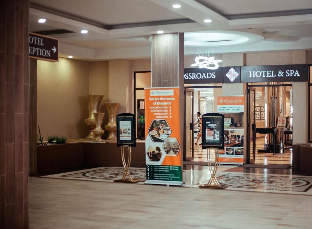 A hotel reception area with a sign for the hotel and spa, and a digital information kiosk.
