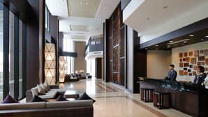 A spacious lobby with a reception desk, seating area, and a view of the outdoors. - Roygent Parks Hanoi (Hanoi)