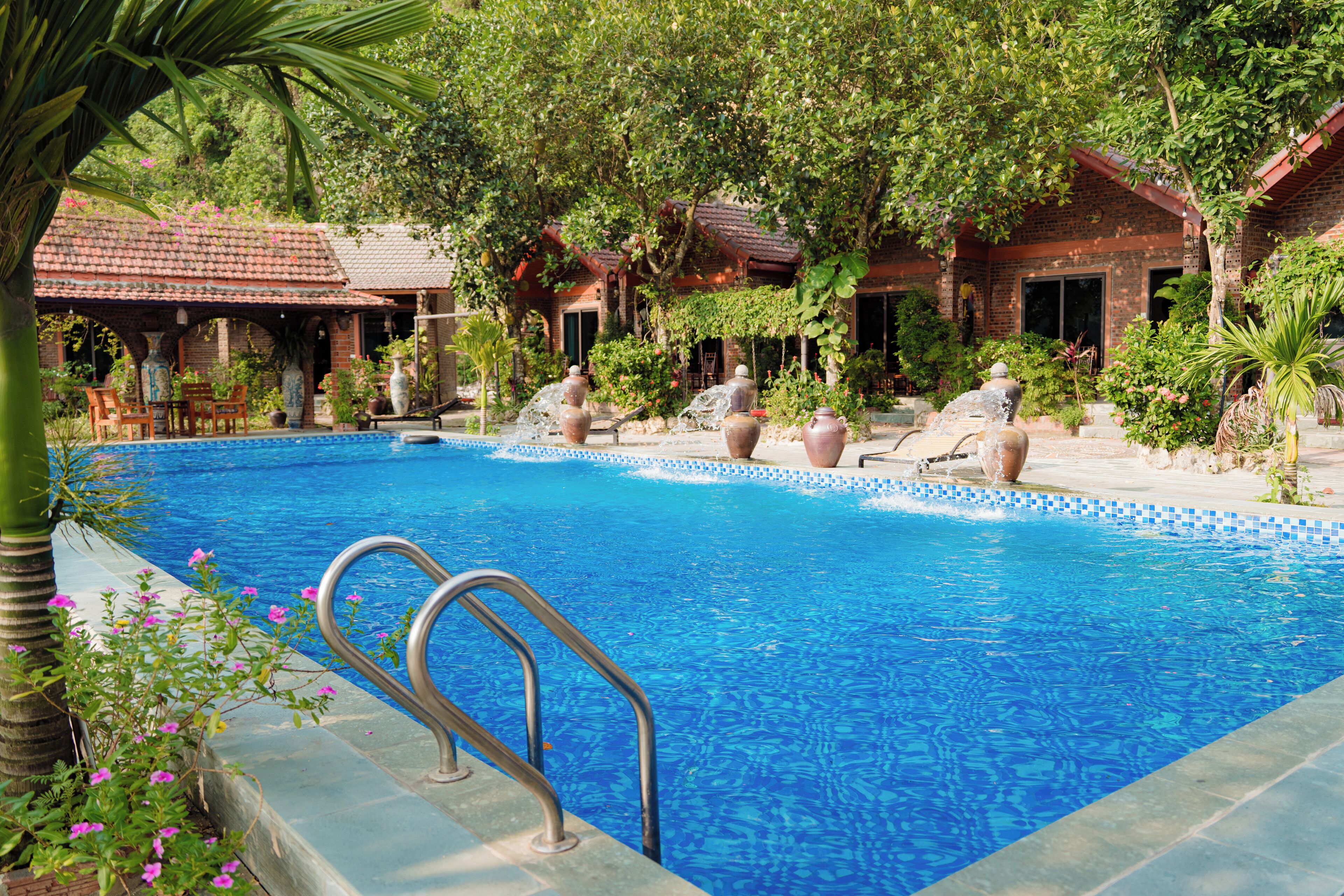 Una piscina al aire libre, sombrillas, tumbonas