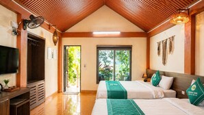 A hotel room with two beds, a TV, a desk, and a view of greenery. - Heritage Soul Bungalow Tam Coc (Nam Hoa Lu)