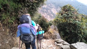 A narrow, rocky hiking trail with hikers carrying backpacks. - Hotel Dream City (Kathmandu)