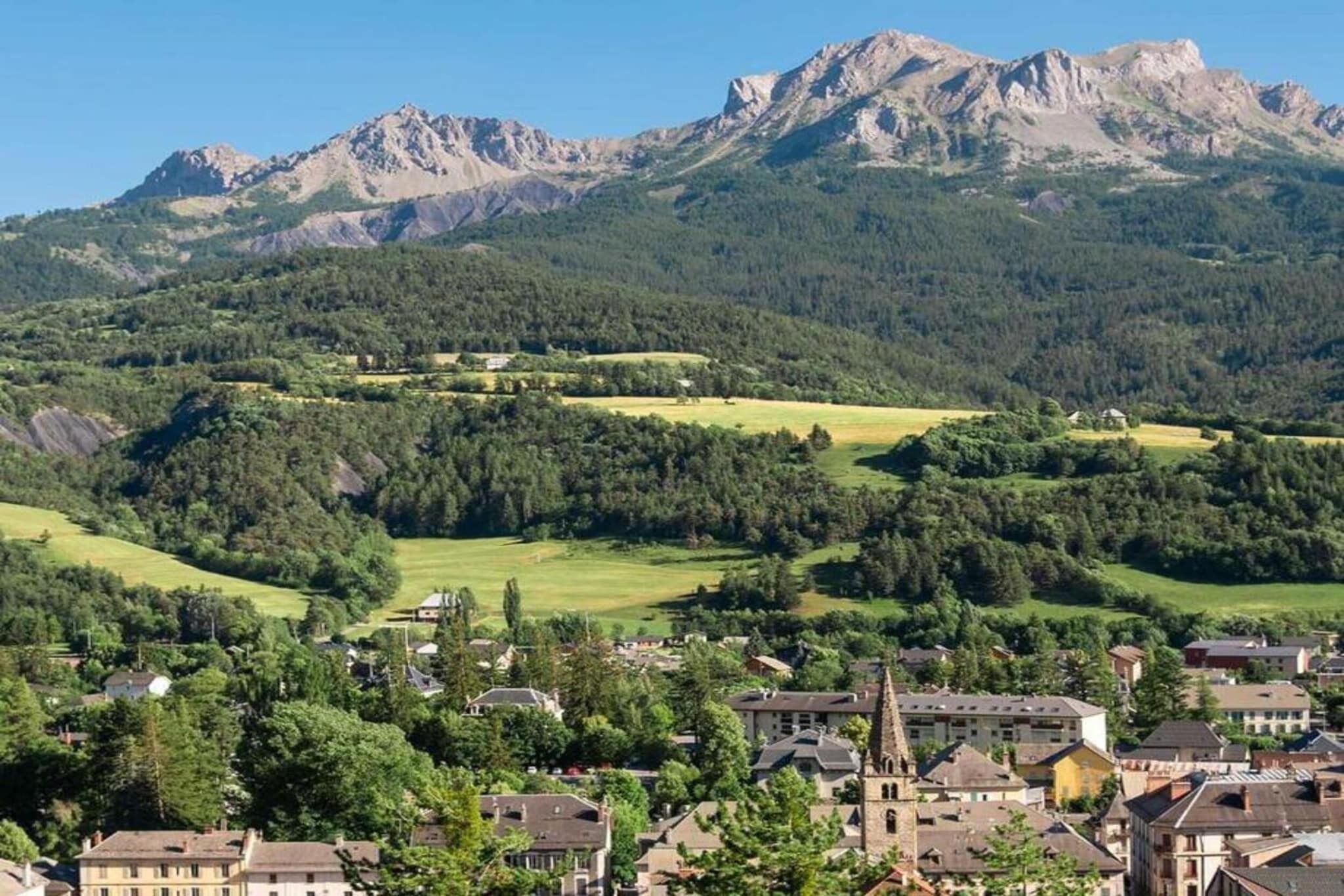 A town with a church, residential buildings, and a mountain range in the background.