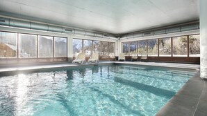 An indoor swimming pool with clear water, large windows, and lounge chairs. - Chalet in Praroustan with Mountain Views (PRA LOUP 1500)