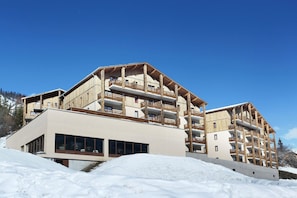Ein mehrstöckiges Hotel mit hölzernen Balkonen und einer modernen Fassade.