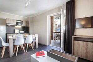 Eine moderne Küche mit Mikrowelle, Kaffeemaschine und Essbereich mit Stühlen und Tisch.