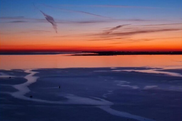 Un paysage plat, avec une étendue d’eau calme et une ligne d’horizon.