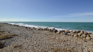 A pebble beach with a stone wall and ocean view. - Amazing home in Sjællands Odde (Sjællands Odde)