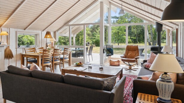 A spacious living area with a high ceiling, large windows, and a cozy seating arrangement. - Amazing home in Sjællands Odde (Sjællands Odde)