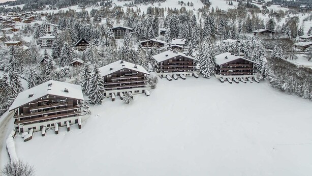 A snow-covered lodge with multiple floors and balconies, surrounded by trees and mountains. - Duplex 2-bed apartment, terrace, near slopes in Megève (Megève)