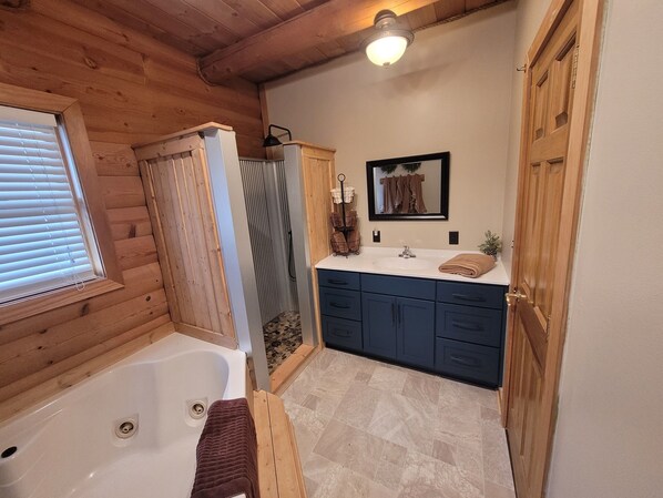 A bathroom with a wooden interior, a bathtub, a shower, and a sink with a mirror above it.