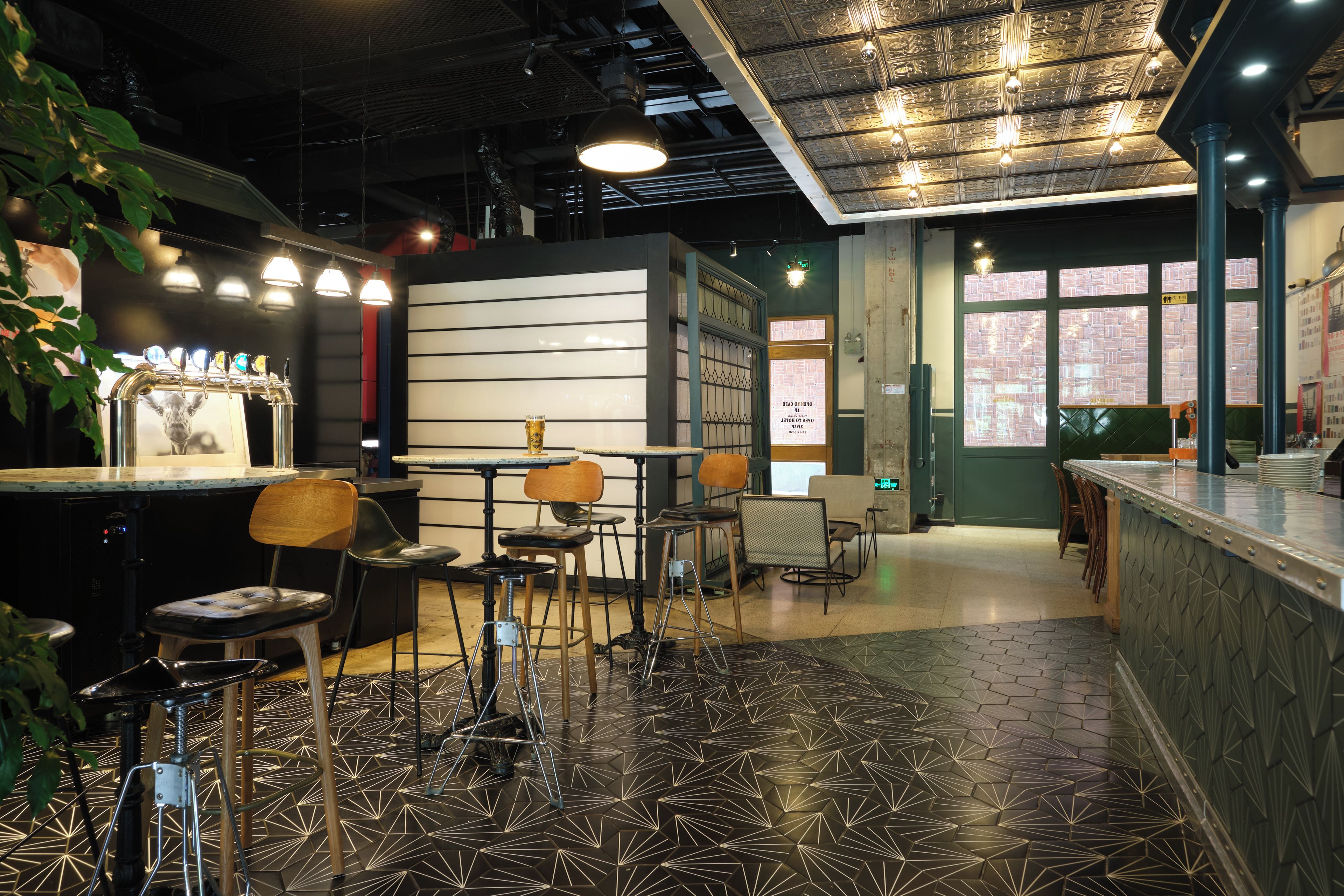A bar area with stools, a counter, and a decorative ceiling.