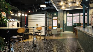 A bar area with stools, a counter, and a decorative ceiling.