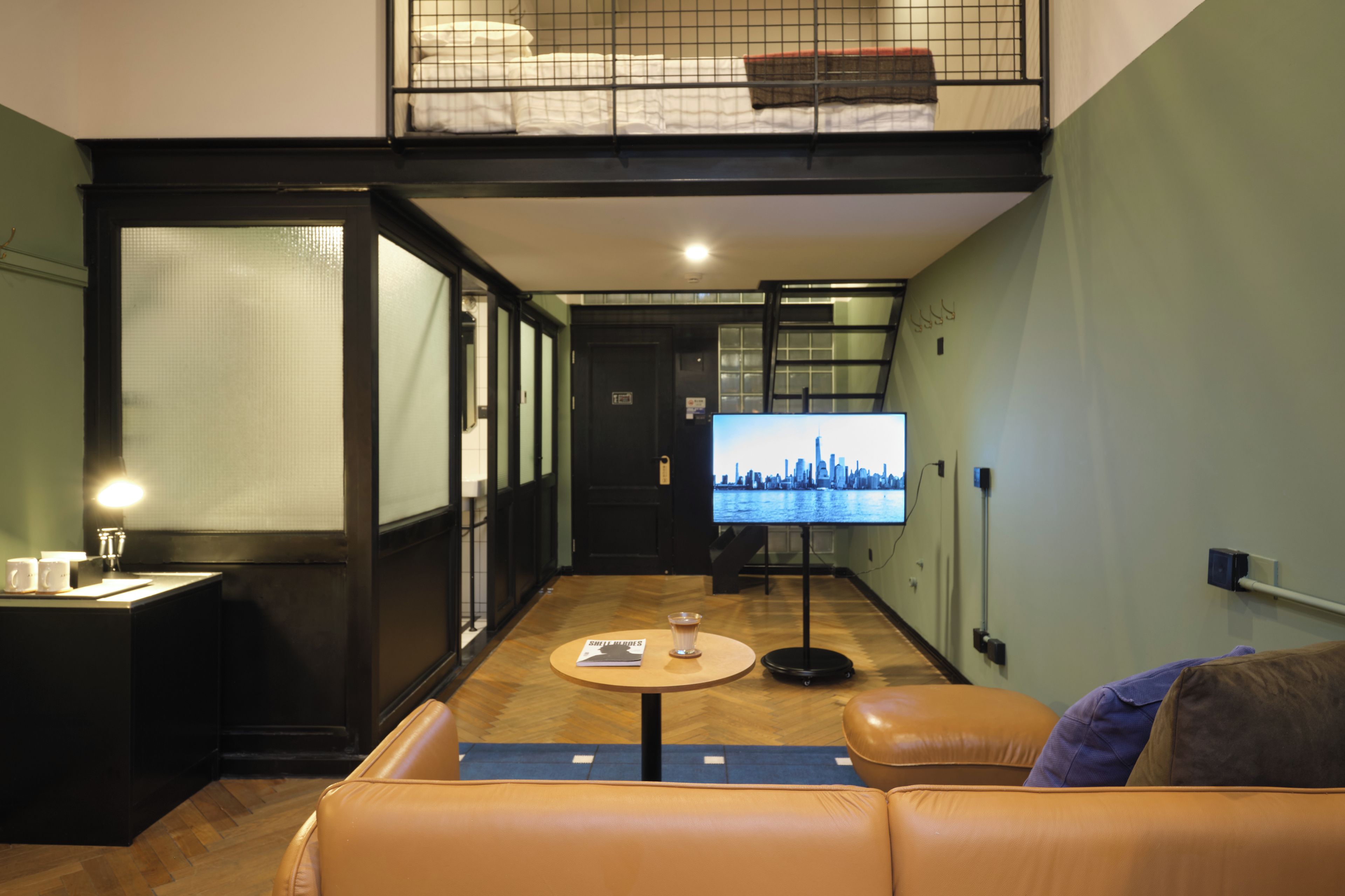 A modern living room with a sofa, a coffee table, and a television displaying a cityscape.