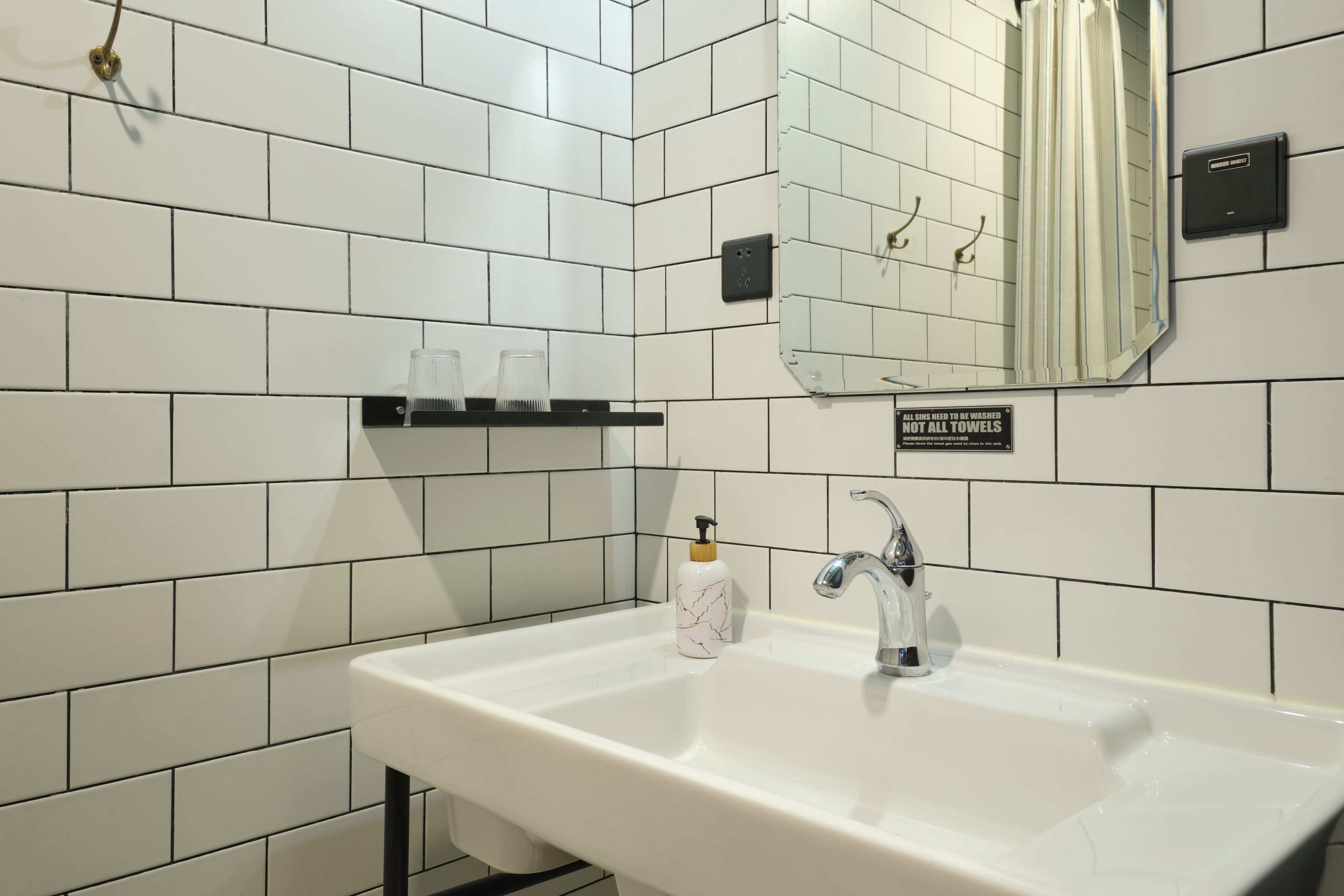 A bathroom with a white sink, a mirror, and a towel rack.