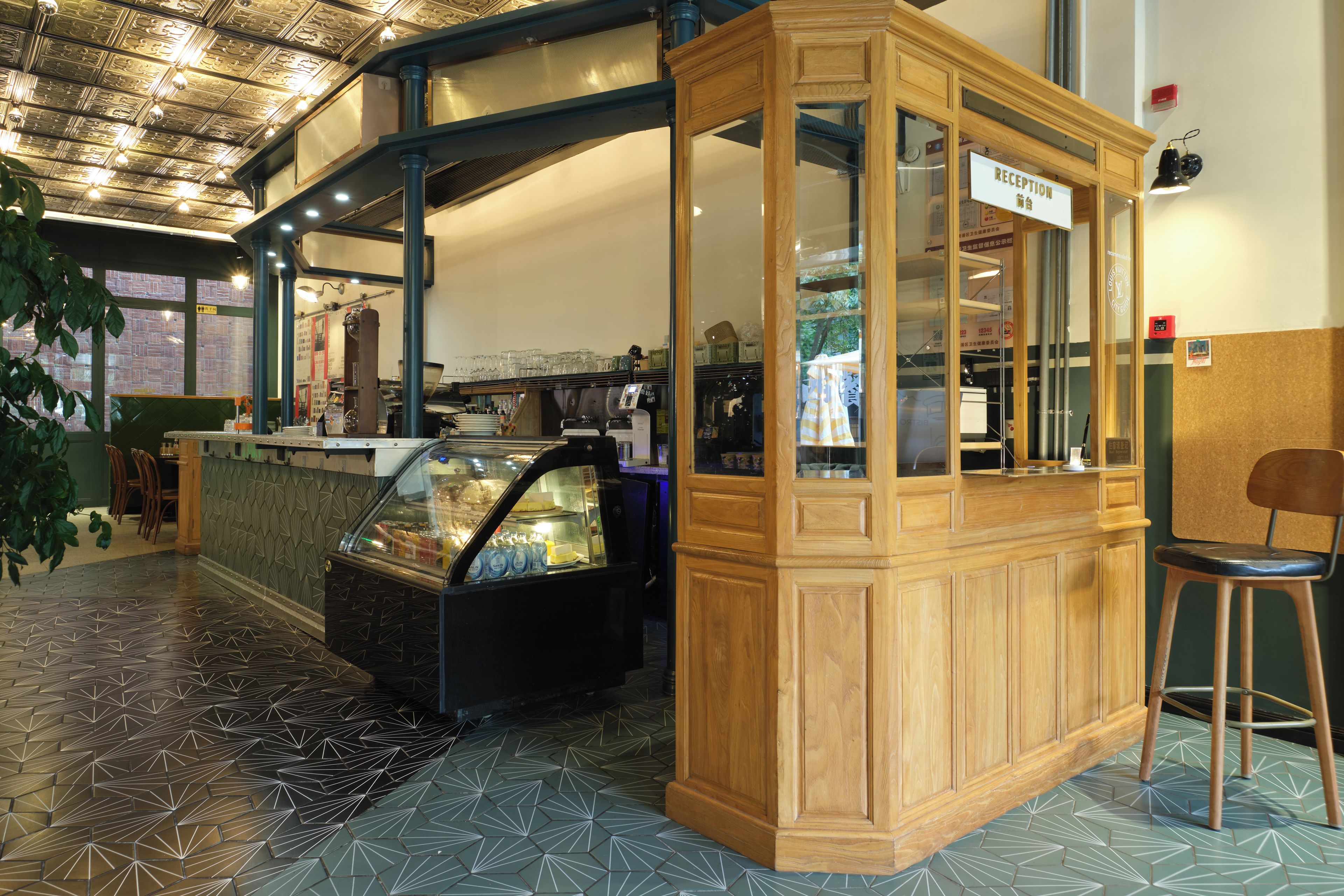 A reception area with a wooden counter, a glass display case, and a seating area with a chair.