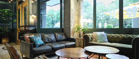 Ein stilvoller Lounge-Bereich mit Ledersofas, einer Holzbank und einem runden Couchtisch.
