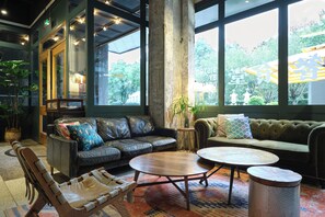 Un espace détente moderne avec des canapés en cuir, un banc en bois et une table basse ronde.