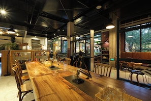 Un vaste espace dédié à la salle à manger, avec une longue table en bois, de nombreuses chaises et un aménagement intérieur moderne.