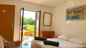 A bedroom with a bed, a chair, a desk, and a view of the outdoors. - Sreser Dubrovnik Apartments Urlic (Janjina)