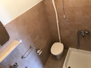 A small bathroom with a toilet, a shower, and a bathtub.