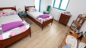 A bedroom with two wooden beds, a small table, a chair, and a dresser. - Villa Salamander (Komen)