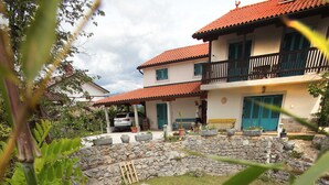 A house with a stone pathway, a small pond, and a well-maintained garden. - Villa Salamander (Komen)
