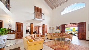 Uma sala de estar ampla com dois sofás, uma mesa de centro e uma janela grande.