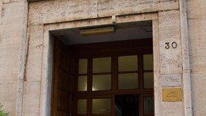 Entrada de un edificio con una puerta de madera y un letrero con el número 30.