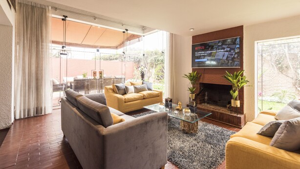 A modern living room with a sofa, armchairs, a coffee table, and a fireplace. - Lima Fabulous  House 5br sleep8 Next Mall (Lima)